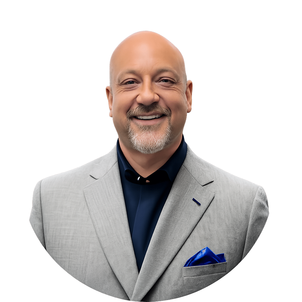 David Joles with a goatee, smiling and wearing a light gray suit jacket, a dark shirt, and a blue pocket square, poses against a plain white background.